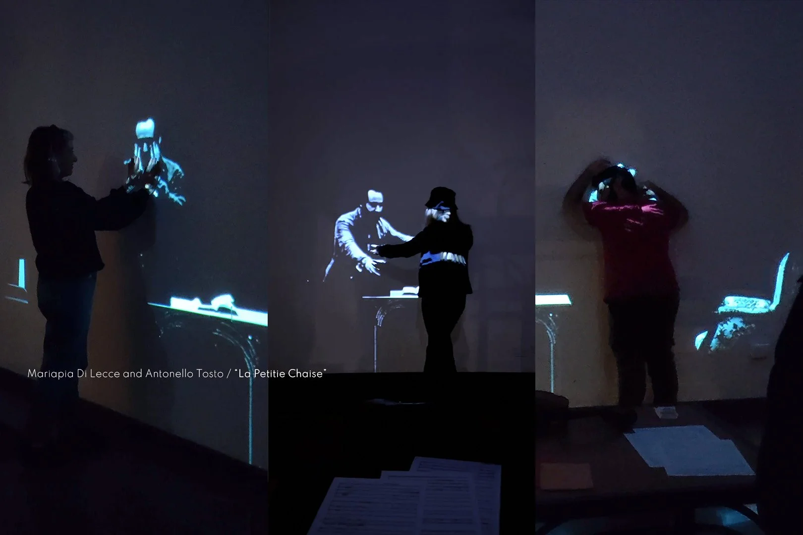 Two women and one man interacting with a projection on a wall, which shows a DJ and a table. The women are on either side of the man, with one woman holding her hands up and the other woman touching her forehead.