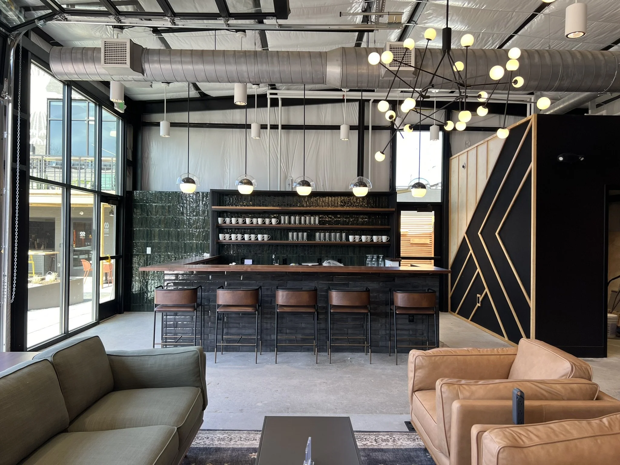  Once a dilapidated garage, the revitalized annex now features full-height glass garage doors that blur the boundary between indoor and outdoor, creating a flexible space for work and social gatherings. 