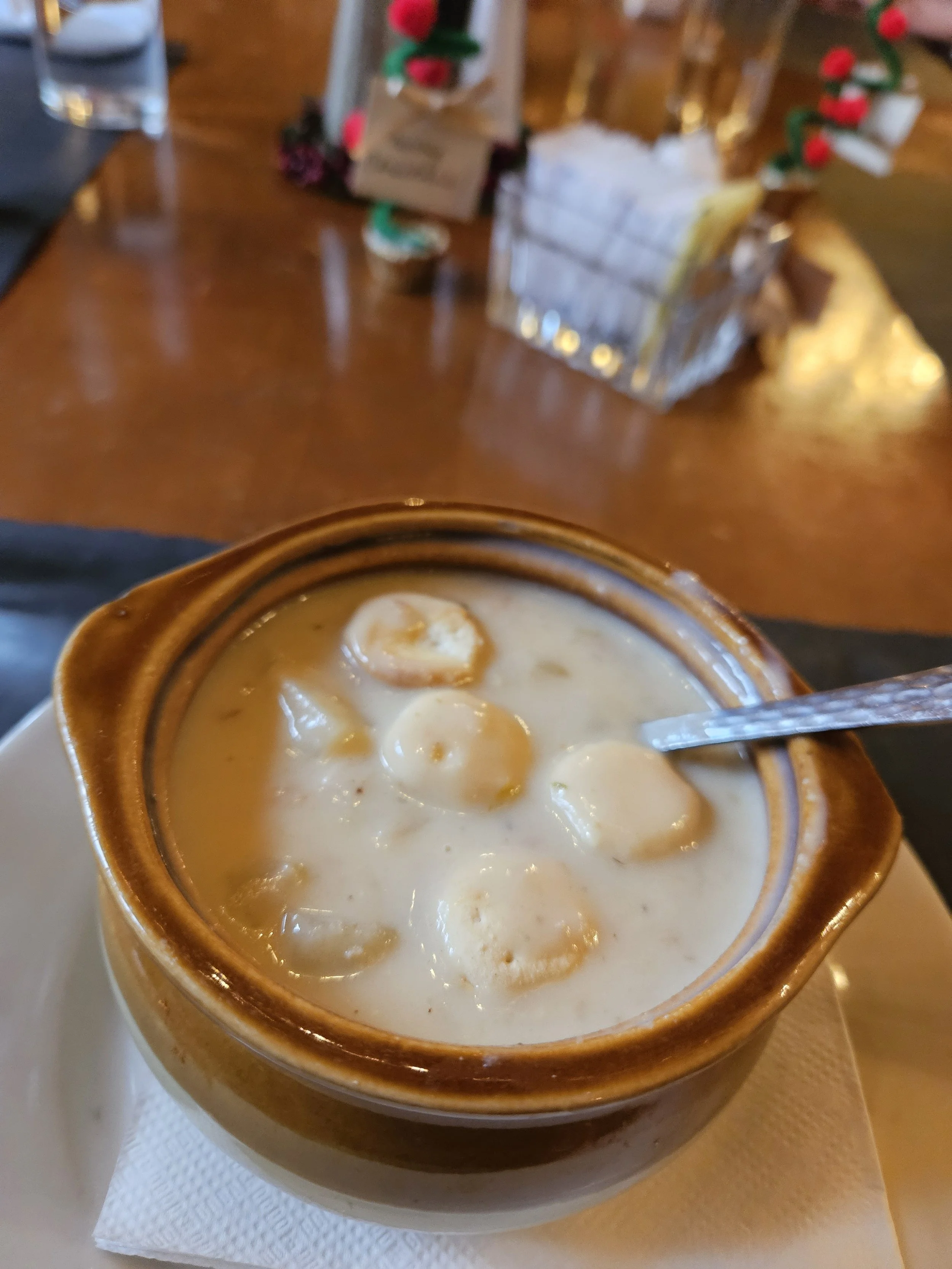 A bowl of clam chowder with crackers