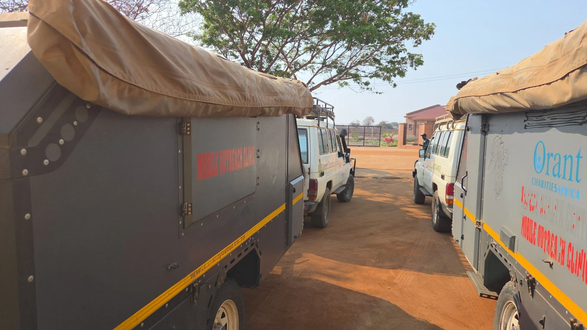 Two Orant Charities Africa mobile outreach clinic vehicles parked at the health centre in central Malawi