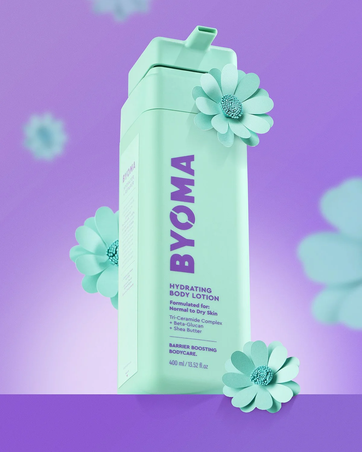 Byoma branded green skincare bottle standing on a purple background with teal floral elements, clean commercial product photography with bold complementary color styling
