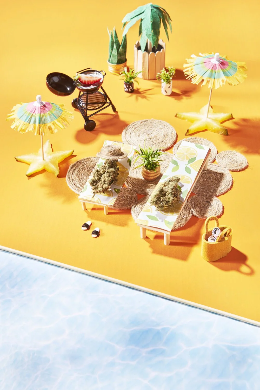 Playful flat lay of wellness products scattered among miniature beach umbrellas and tropical accessories on a bold yellow and blue split background