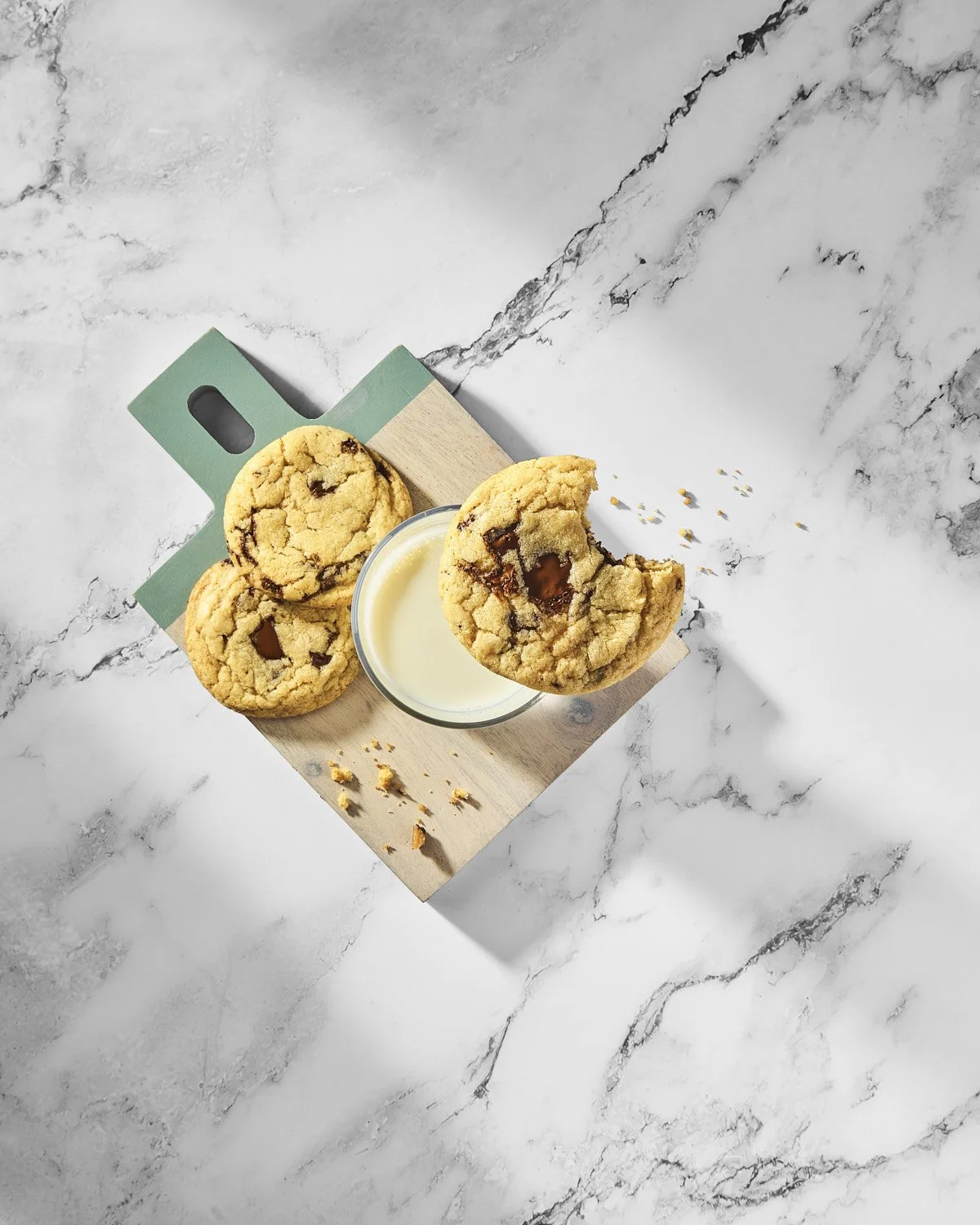 Minimalist milk and cookies arranged sculpturally and shot on a marble surface