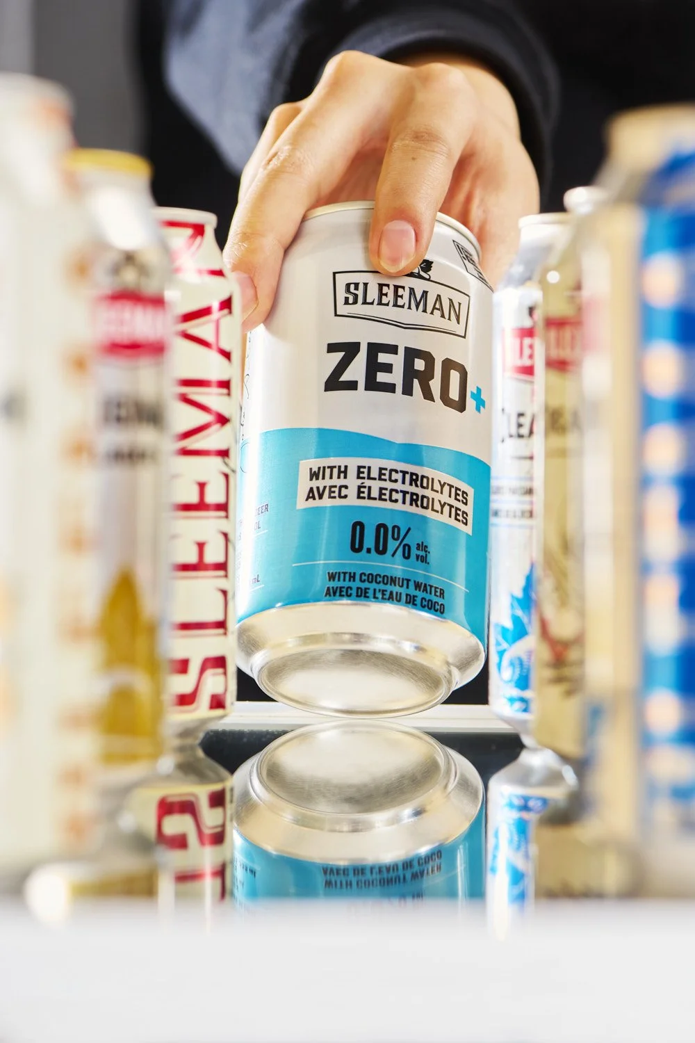 Front view of branded zero alcohol can standing upright on a fridge shelf, surrounded by other beers, seen from inside the fridge, clean commercial product shot with soft studio lighting and minimal background
