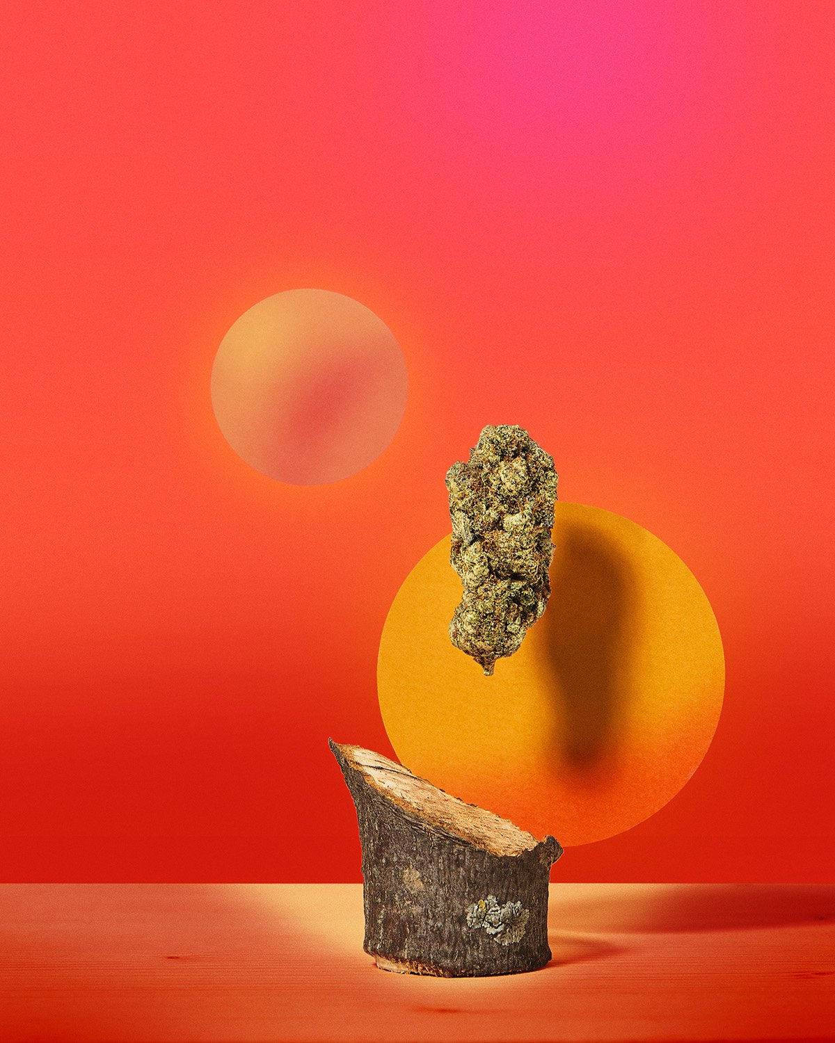Minimalist artistic product shot of a small decorative object or cannabis flower on a sculptural base against a bold red to orange gradient background