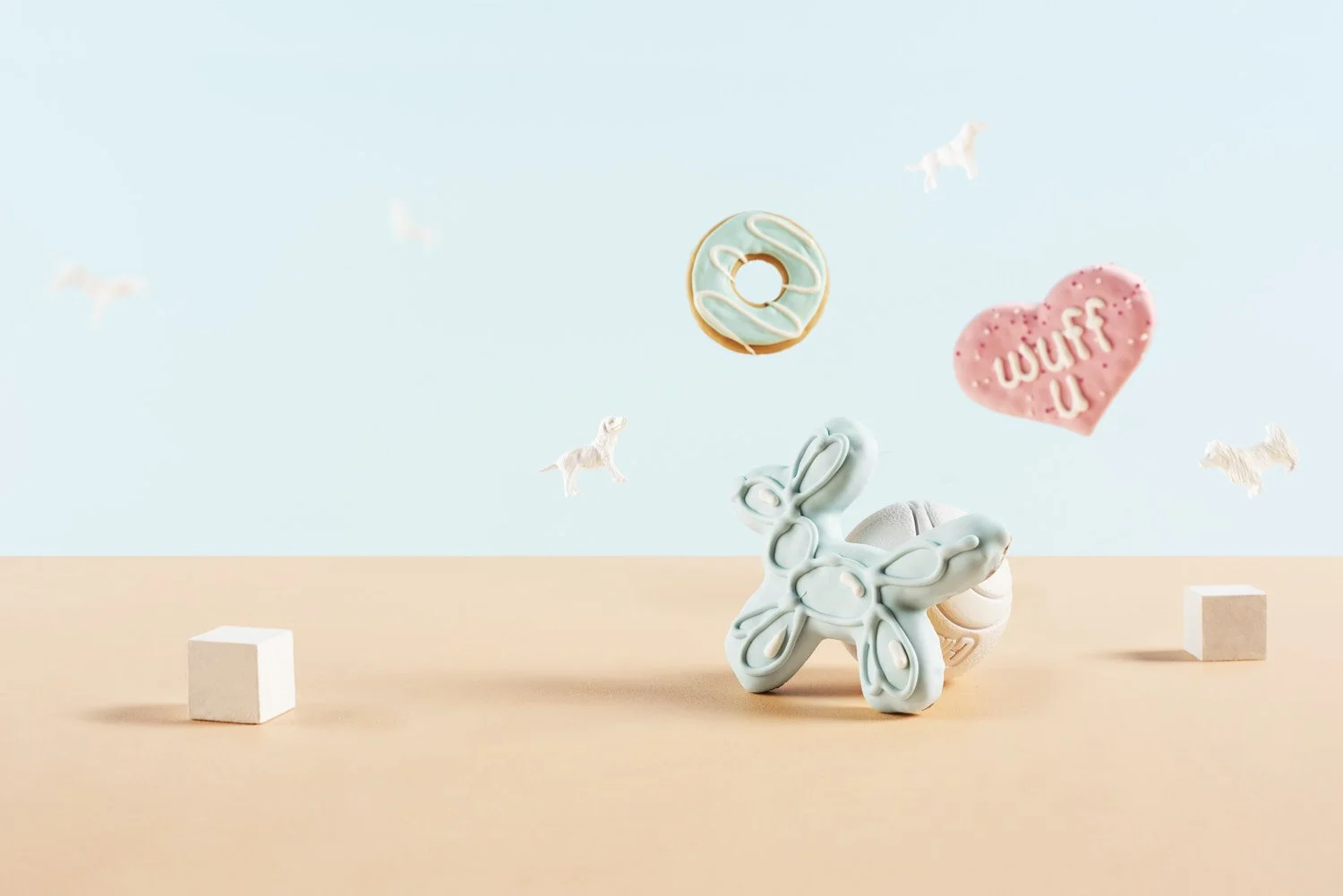 Whimsical pastel blue scene with a small ceramic bunny figure, a heart decoration, and a donut, miniature lifestyle product styling with soft even light