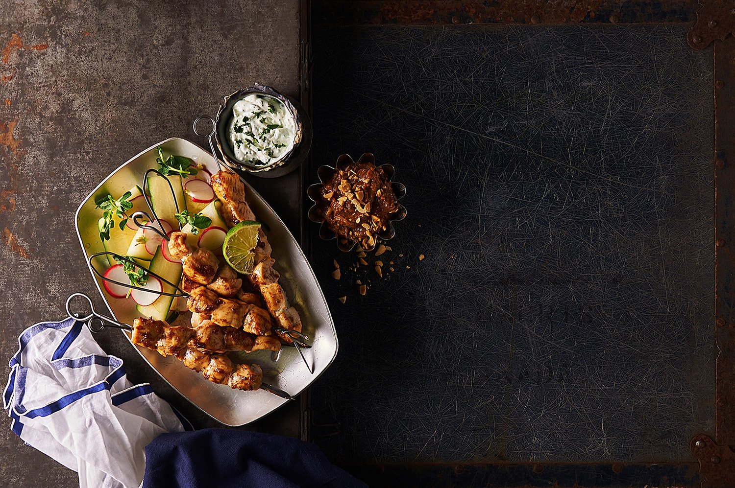 Roasted chicken skewersbowl topped with seeds and greens, placed on a dark textured surface with soft directional lighting