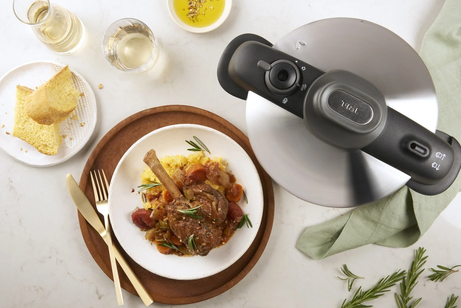 Plated braised meat dish with a rich glossy sauce, served with roasted baby potatoes on a warm-toned ceramic plate against a soft neutral background
