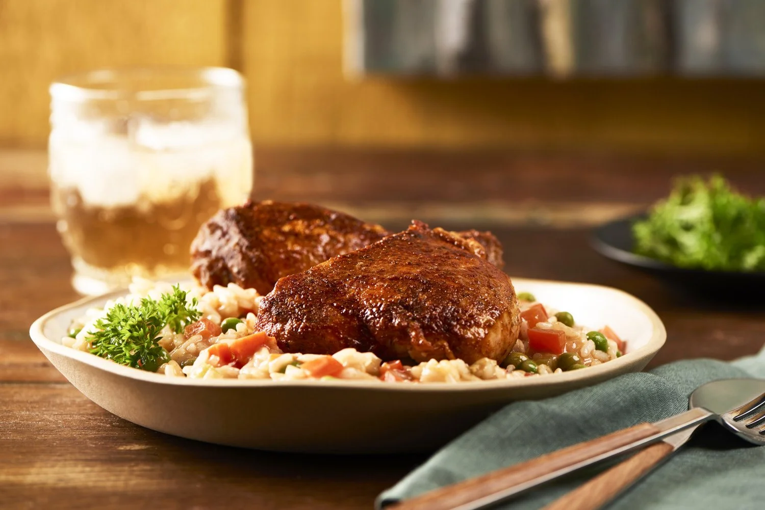 Glazed and roasted chicken thighs served over steamed rice with fresh herbs in a wide ceramic bowl, warm amber light creating rich golden tones throughout