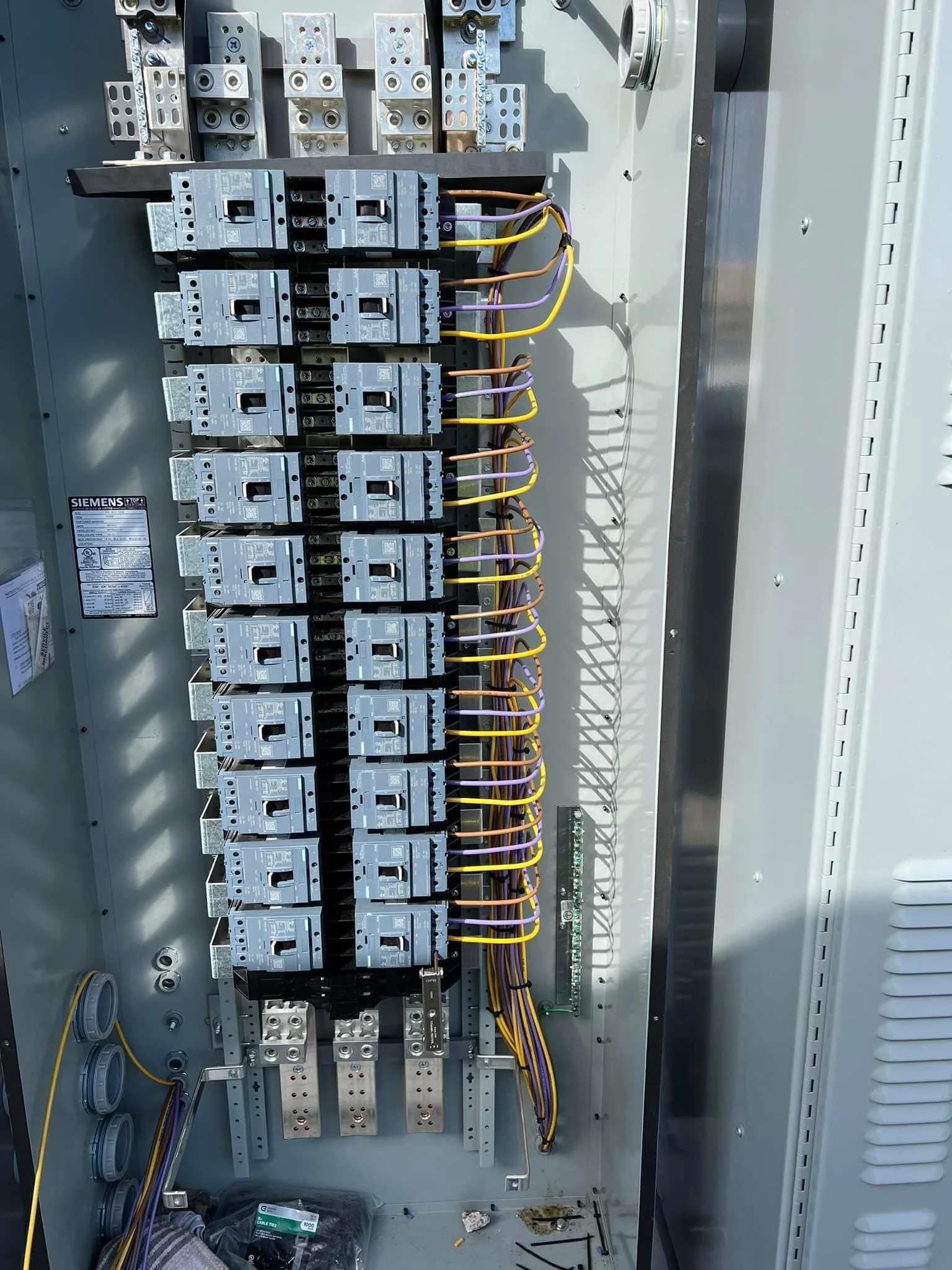 Inside an electrical control panel with multiple circuit breakers and wiring.
