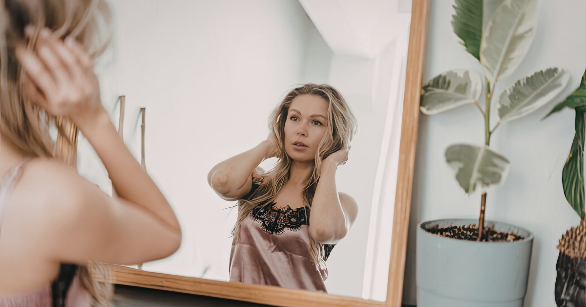 Woman examining hair thinning at the parting — trichologist in Haywards Heath explains the most common causes of hair loss