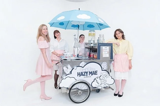 Hazy Mae and her team standing around her Ice Cream Dream Cart, labeled 'Hazy Mae Sundaze'