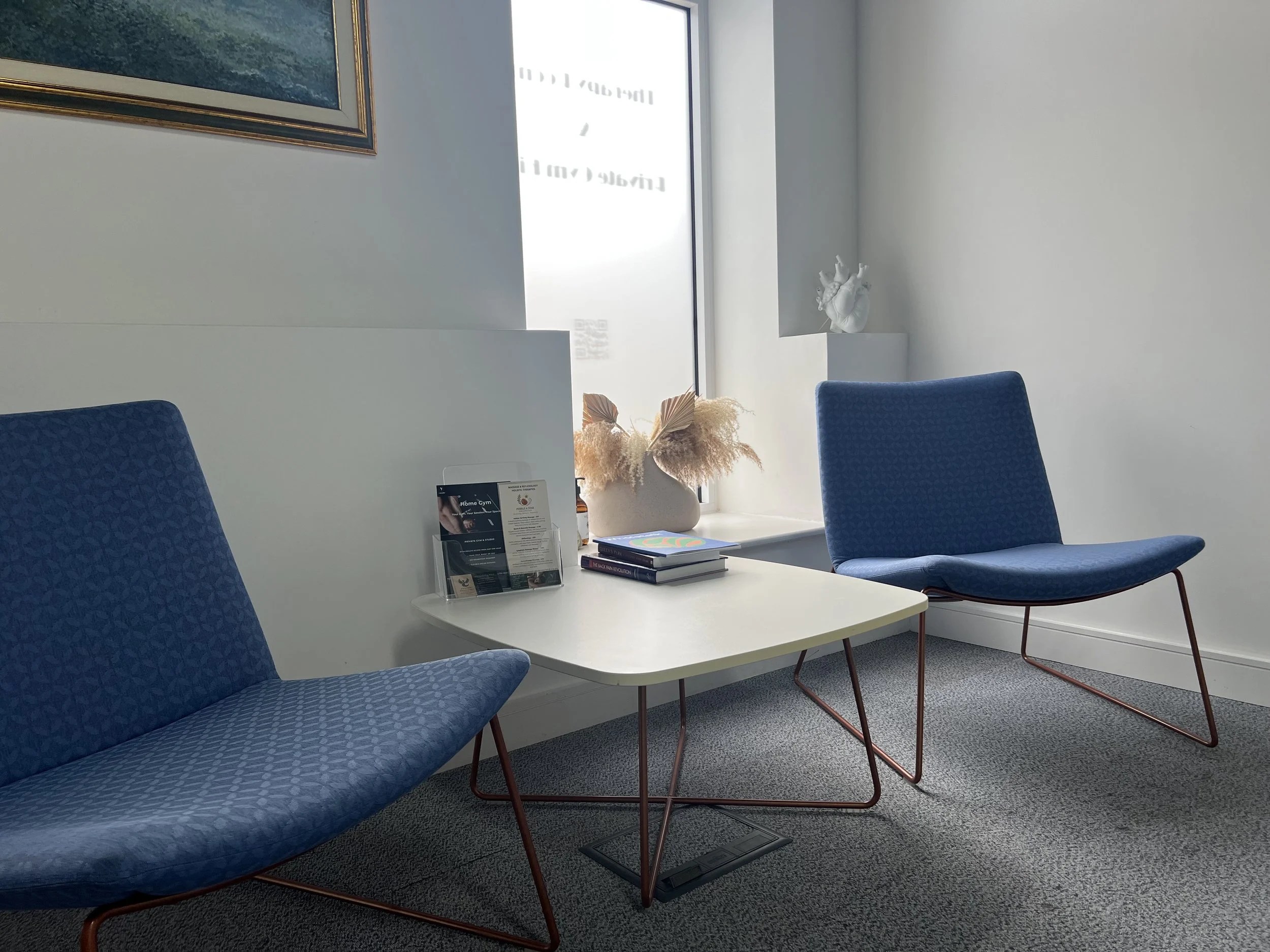 Light-flooded reception area serving clients to therapy rooms and private gym.