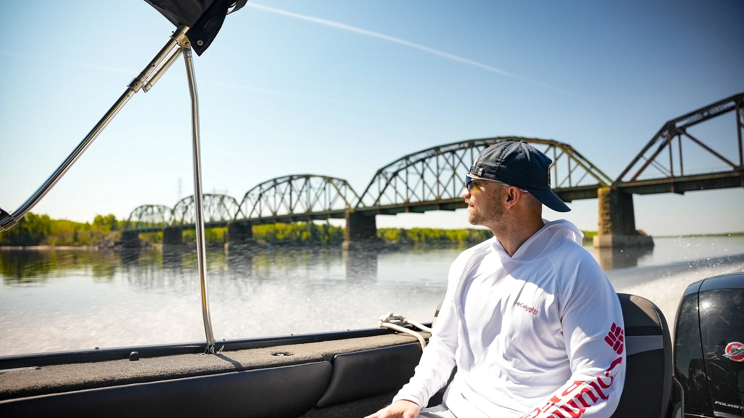 Man sitting on boat with a bridge in the background