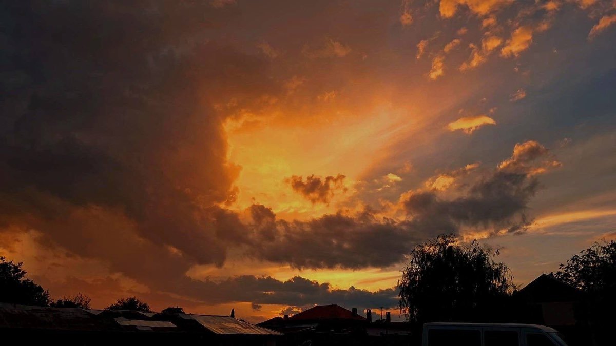 Dramatic summer sky illuminated by orange and golden light, symbolising the powerful and dynamic nature of the Fire element.