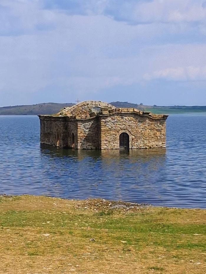 Ancient stone structure beneath a lake representing hidden emotional roots, self-reflection, and emotional healing.