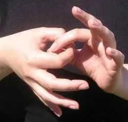 Hands performing a finger link kinesiology muscle test to check food and supplement compatibility - intuitive body testing method