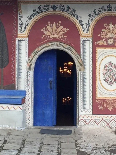 Blue doorway leading into a peaceful interior, symbolizing self-reflection, personal discovery, and the beginning of a healing journey.