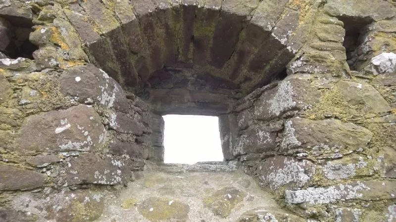 An ancient stone doorway opens onto a bright sky.