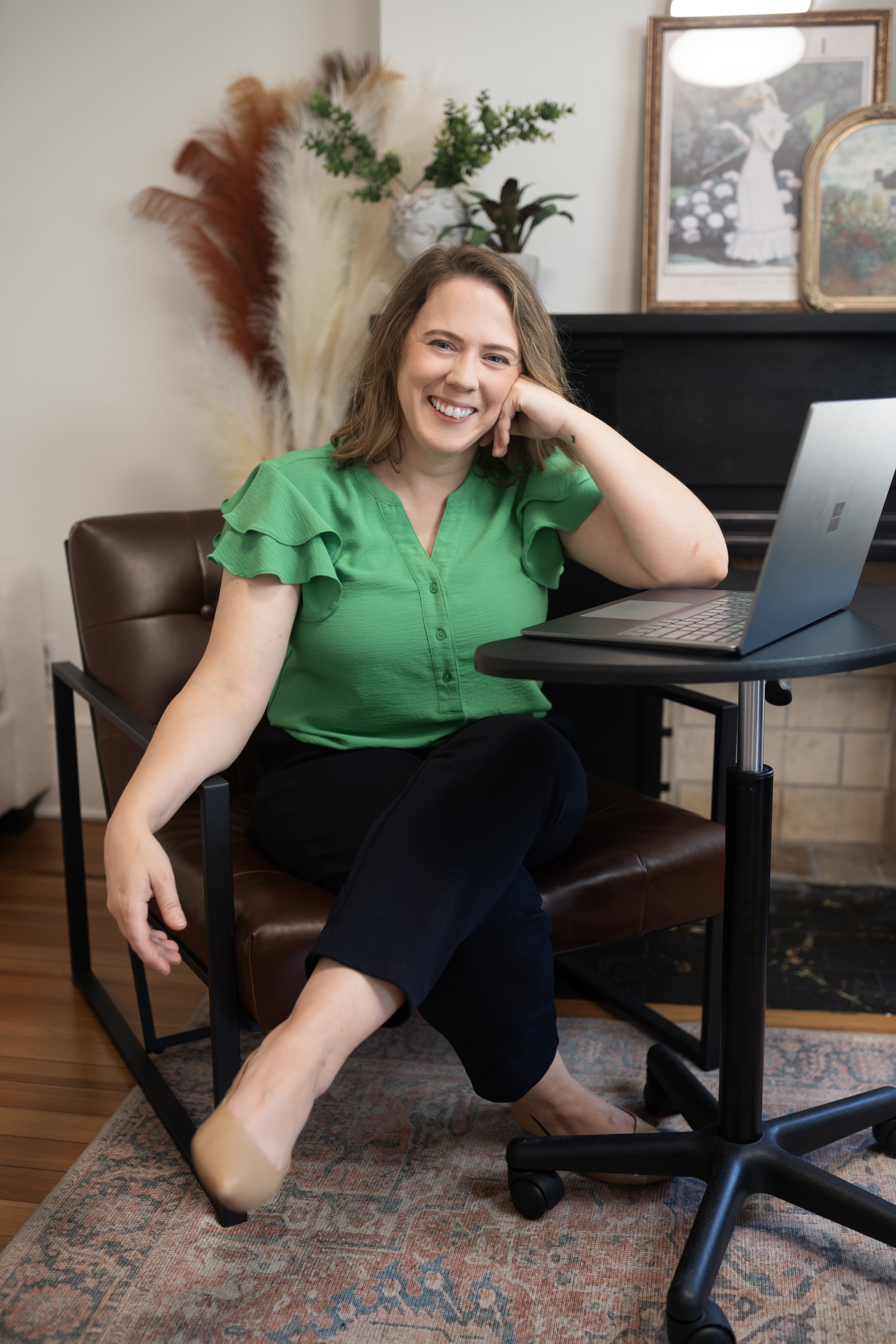 Amanda smiling seated at the computer, leaning on her elbow