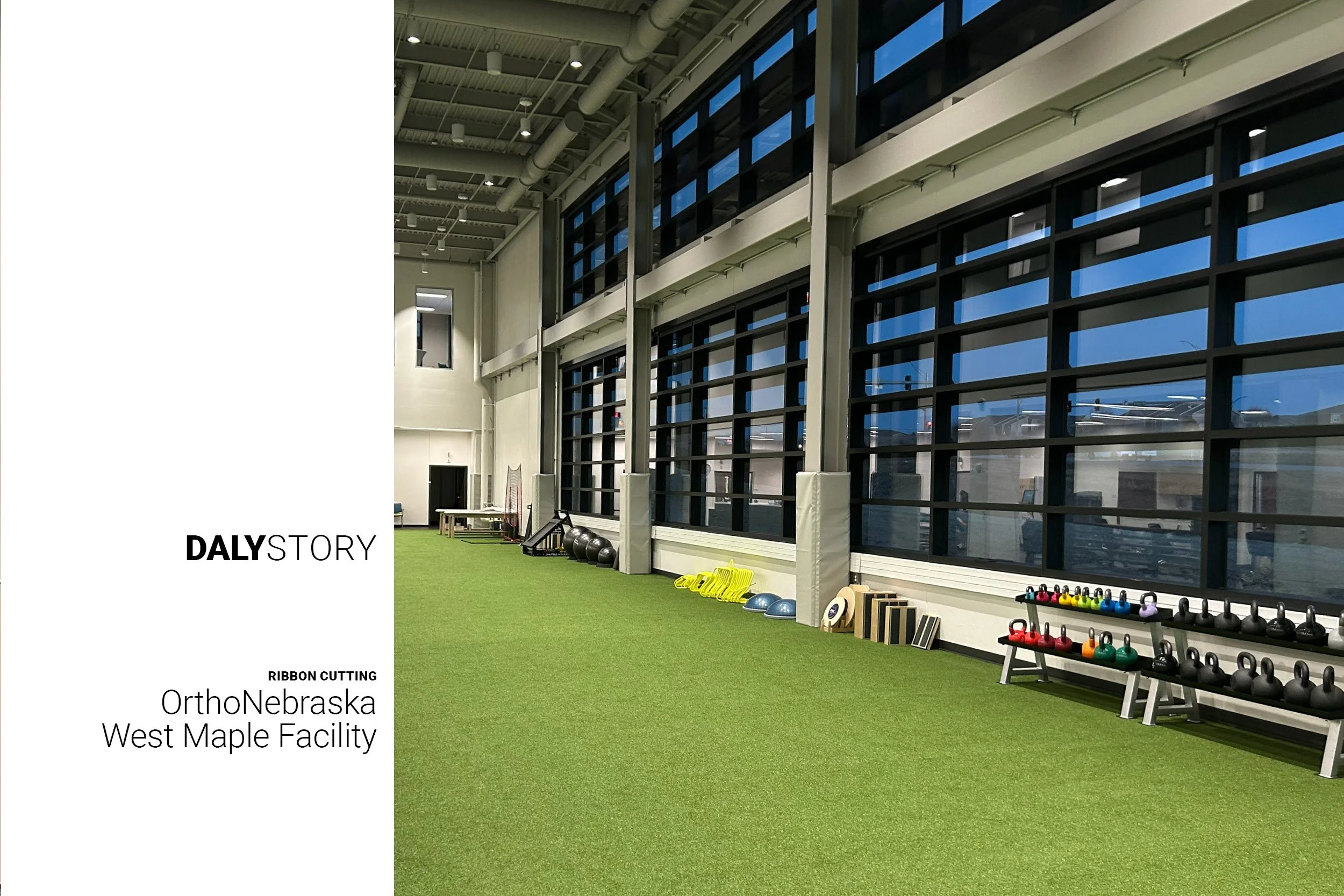Inside OrthoNebraska West Maple Facility. Image of rehabilitation workout space with green turf floors, kettleballs, exercise balls and other equipment along a double-height window wall.