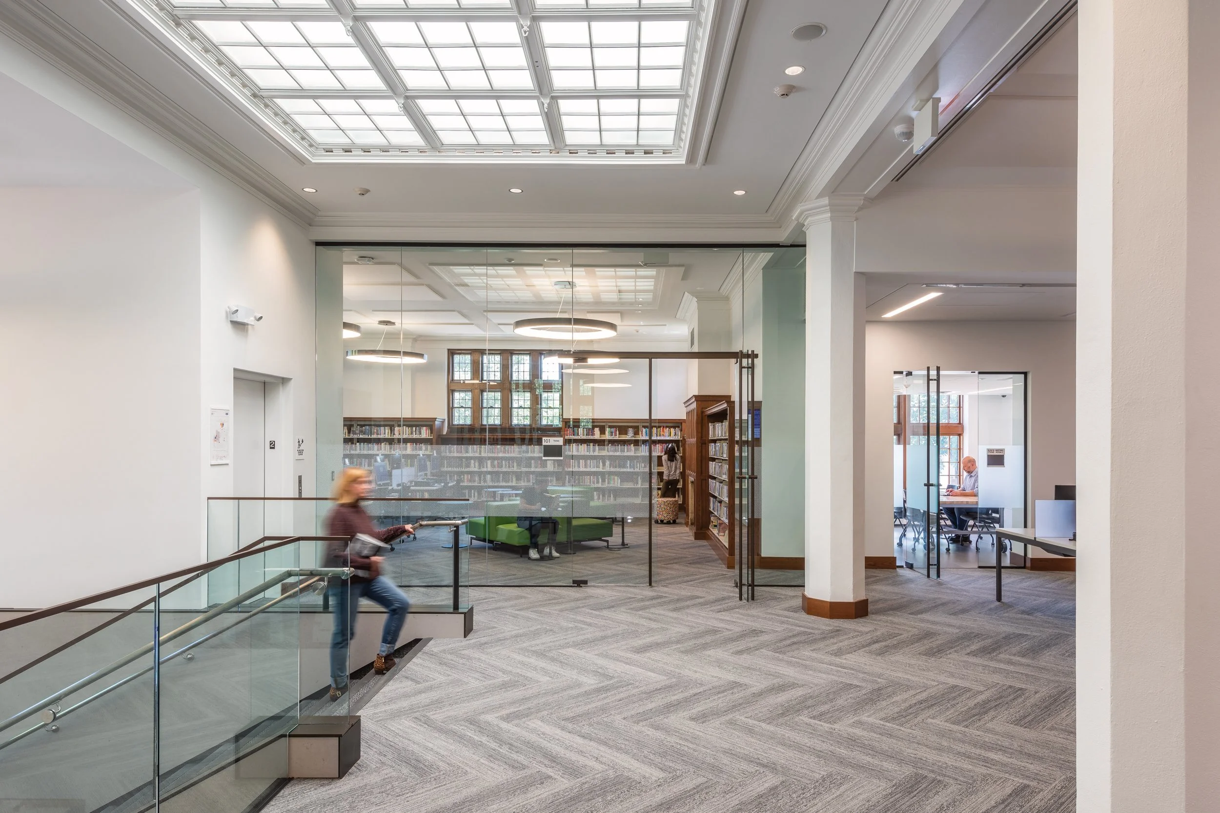 Women walking up stairs to second floor landing of Hosmer Library in Hennepin County