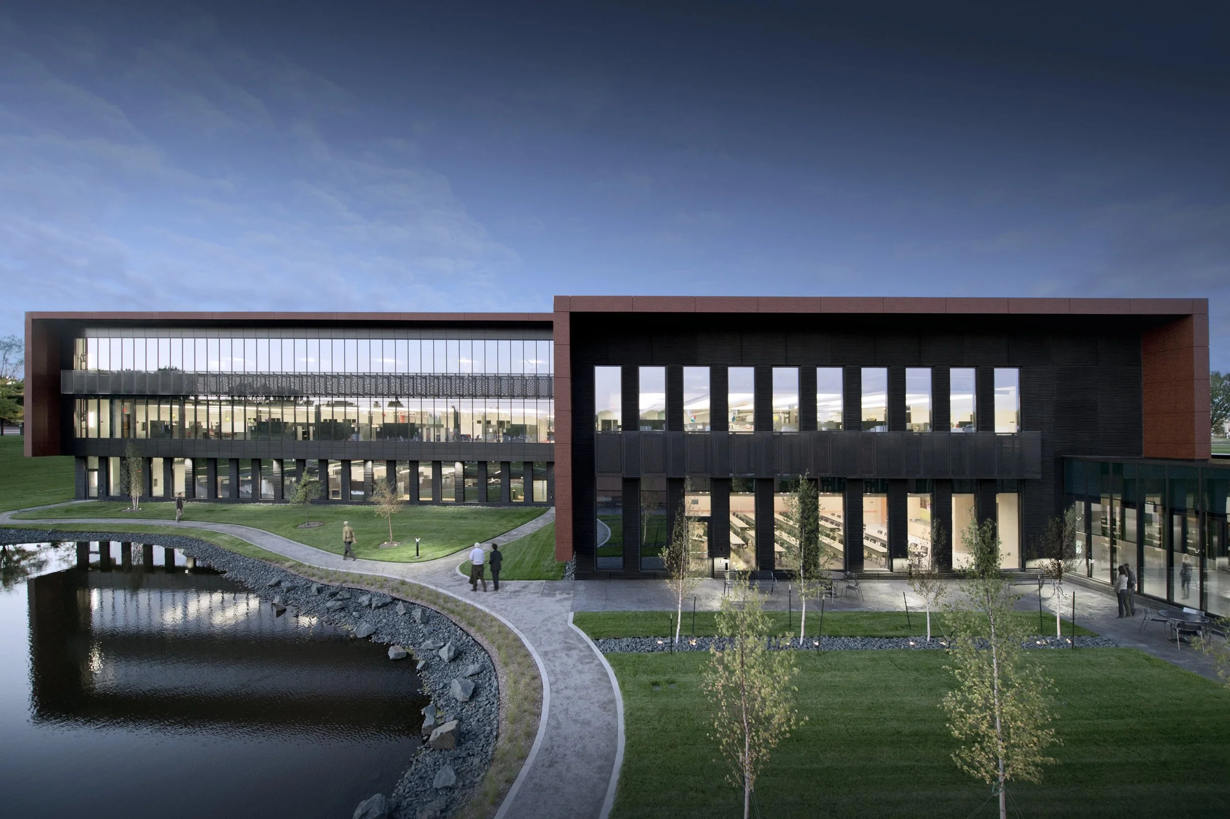 A corporate headquarters with landscaped plaza in the foreground.