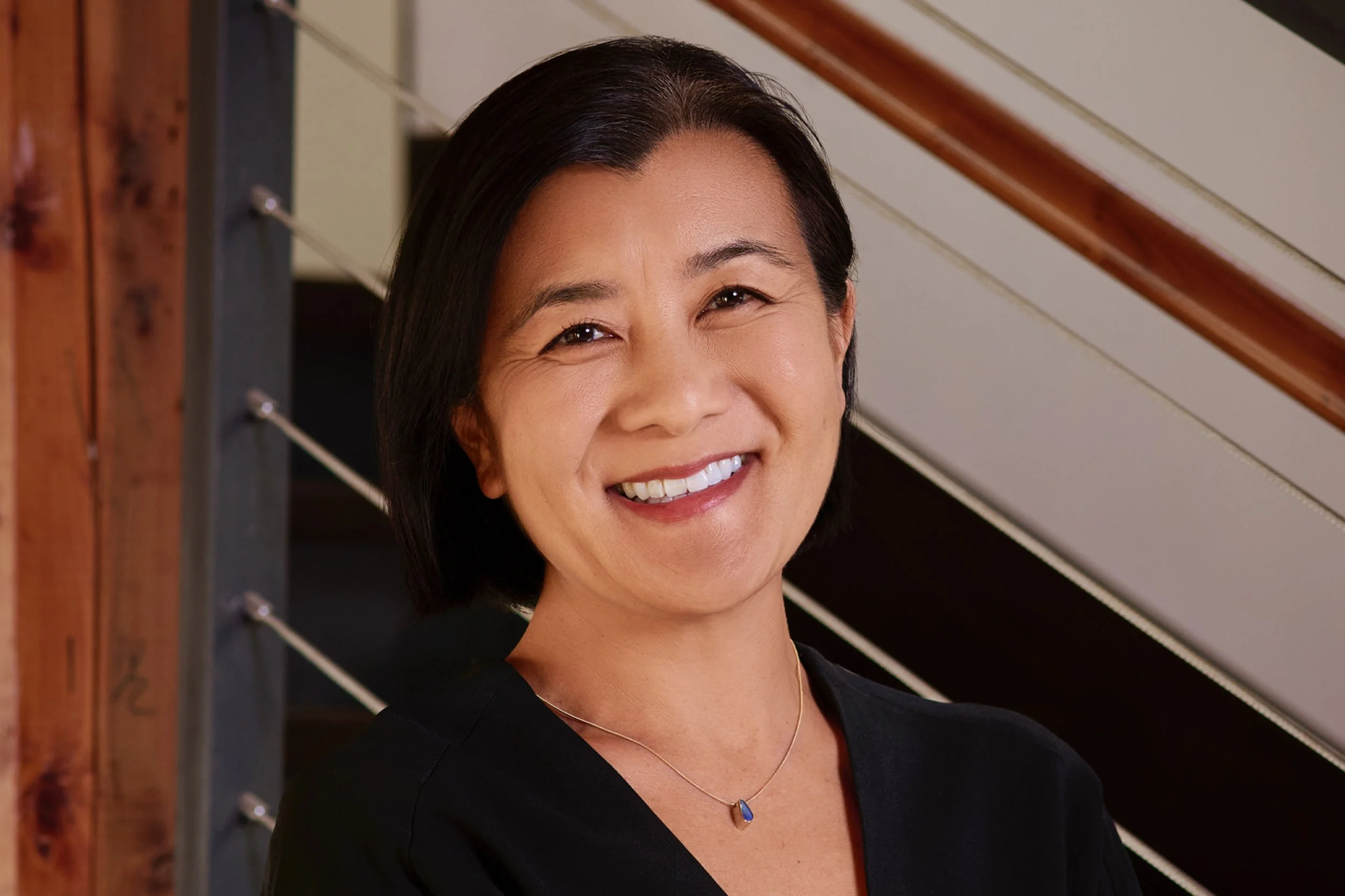 Alison Morita in black in front of office stairs