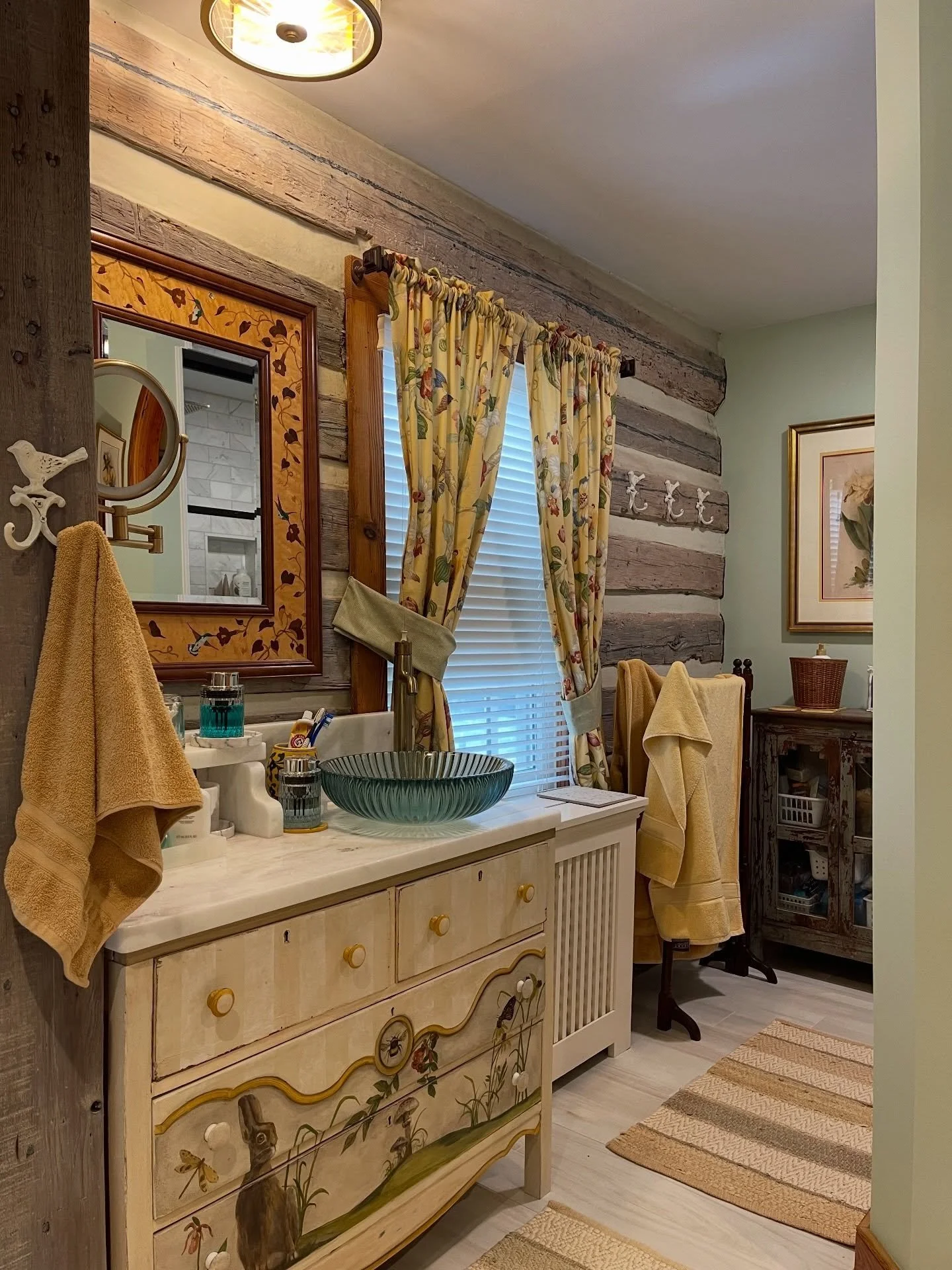 Update your space and maintain the charm! We had fun renovating this bathroom and repurposing a hand-painted chest of drawers into a custom vanity with a magnificent sink. Did you know that a pebble shower floor practically gives you a foot massage w