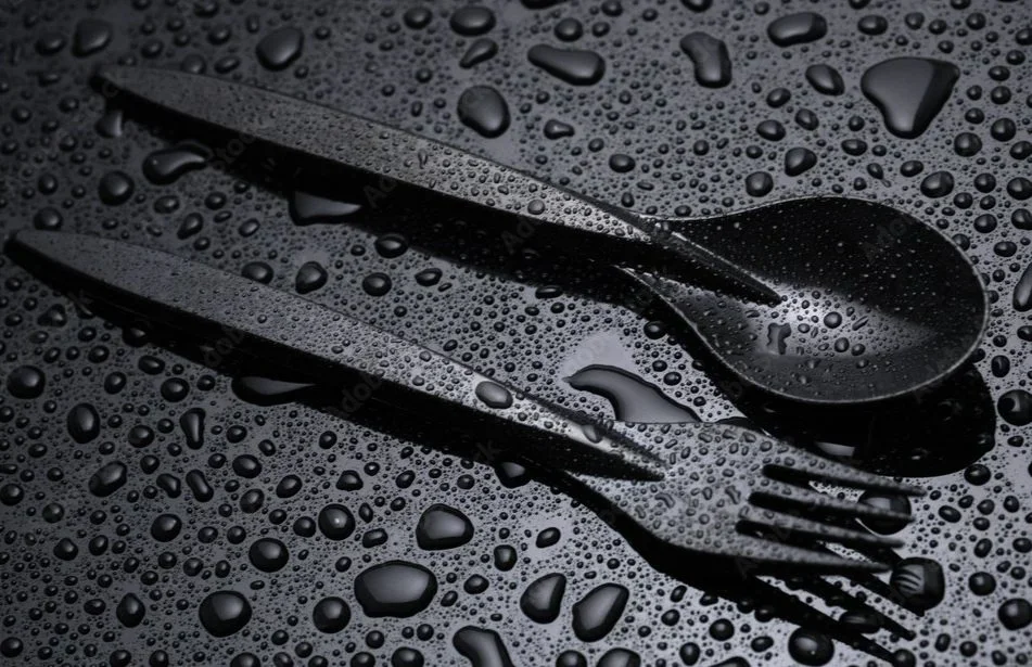 Black cutlery with water droplets on surface