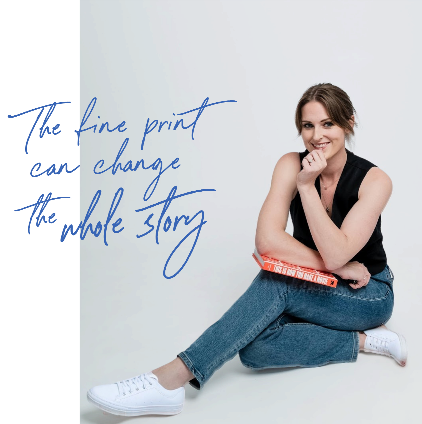 A young woman with short brown hair sitting on a person's lap, smiling and wearing a black sleeveless top, blue jeans, and white sneakers. She is holding a book and resting her chin on her hand against a light gray background.