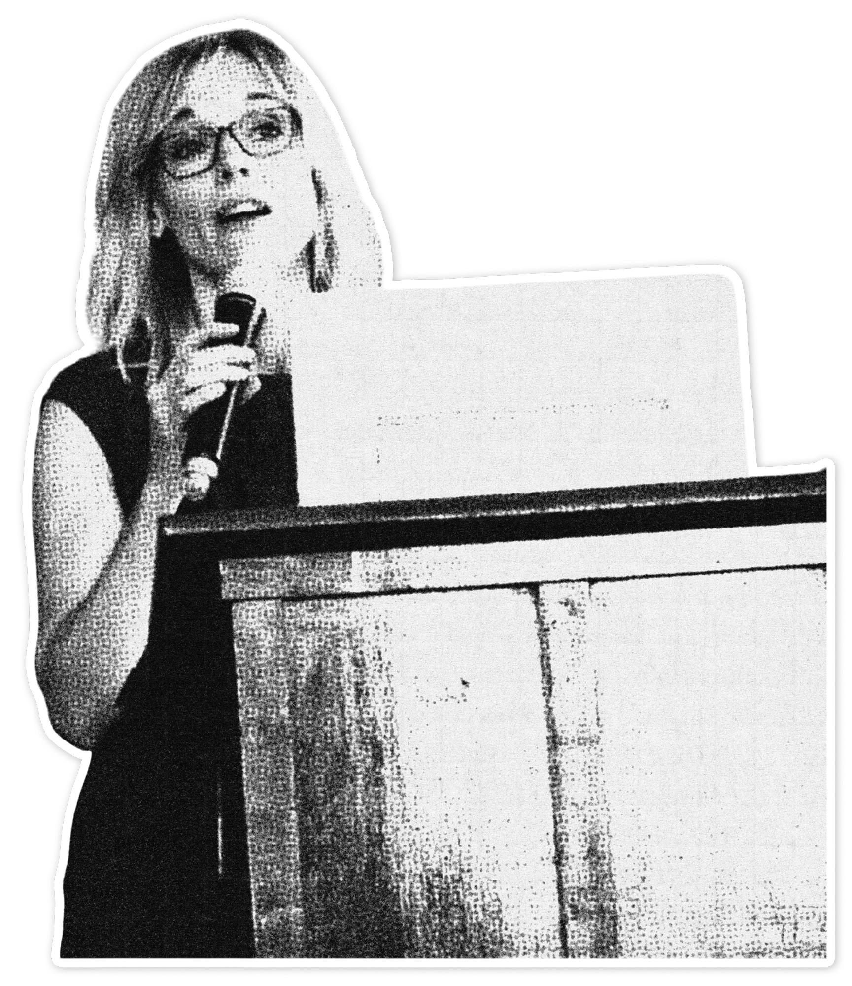 A black and white photo of Susan Wright, president of Theology & Peace, standing at a pulpit and speaking into a microphone.
