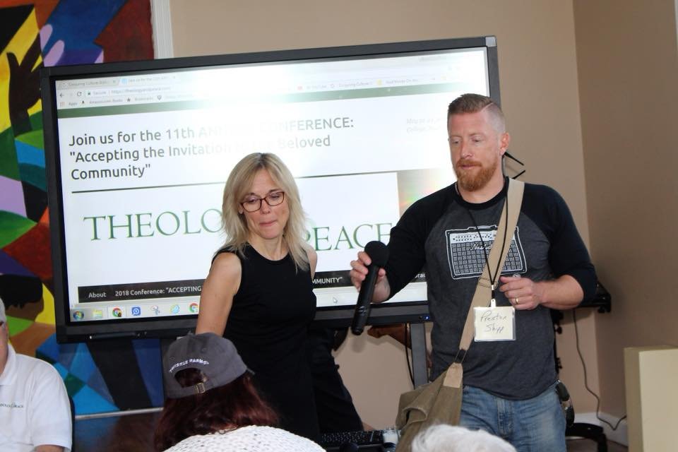 Susan Wright and Preston Shipp stand before a presentation screen in front of an audience.