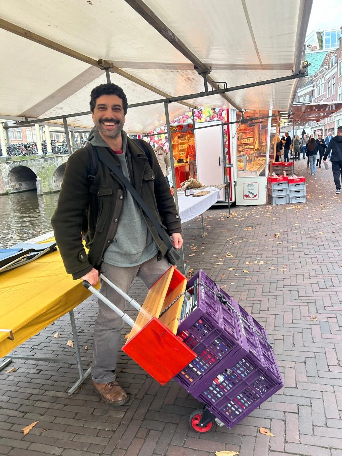 omar amin founder of Heliopolis bookstore carrying crates of books from around the world at the market