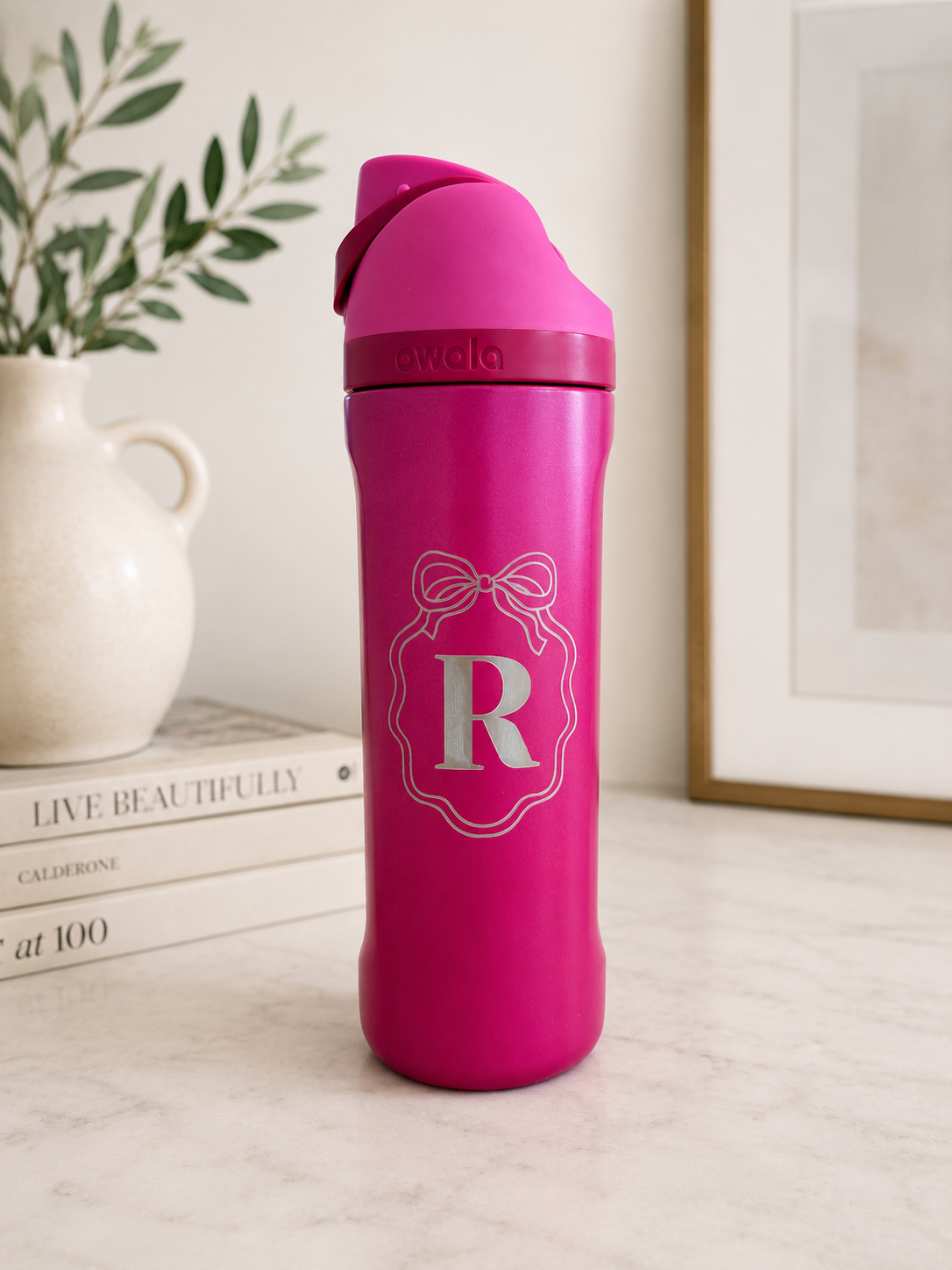 Custom engraved Owala water bottle with name monogram and bow.
