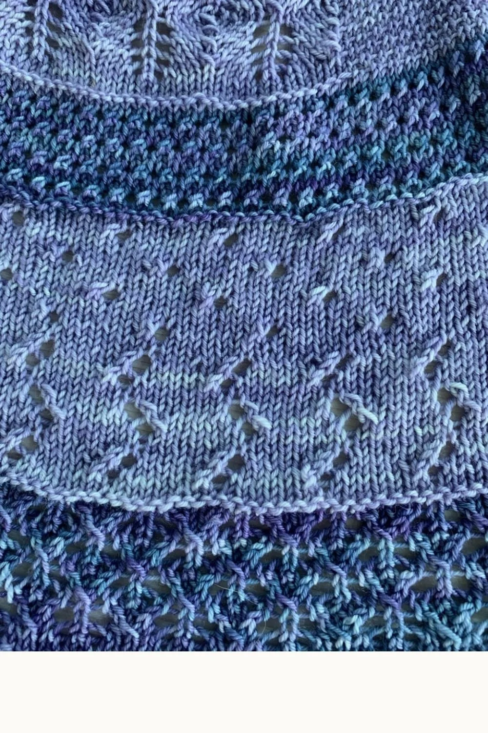 A hand knit lace shawl in shades of purple