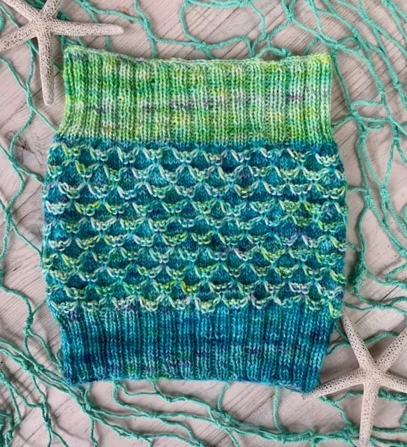 A hand knit cowl using two colors, a medium blue and a speckled light green