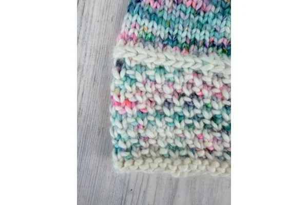 Closeup of the brim of a colorful hand knit hat