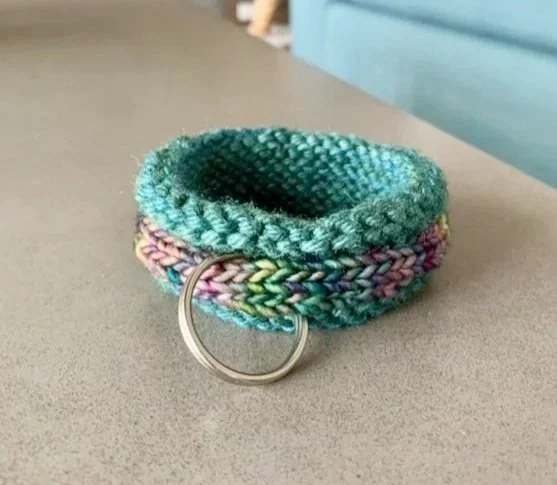 hand knit keychain bracelet on a gray table