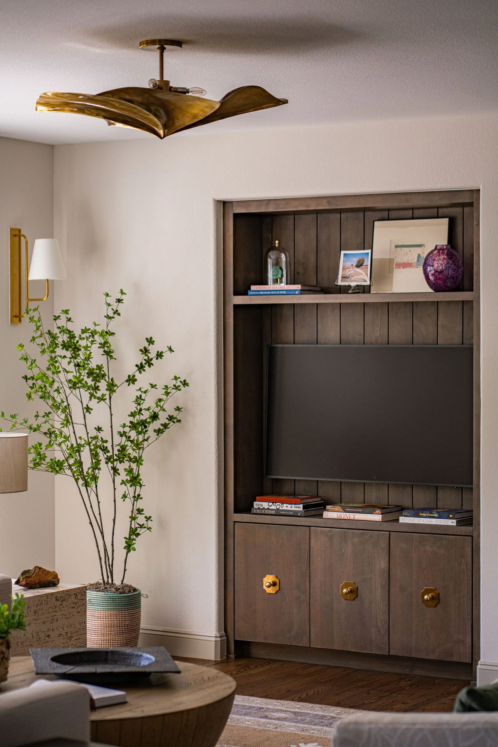 wood tv cabinet with brass hardware and flushmount light