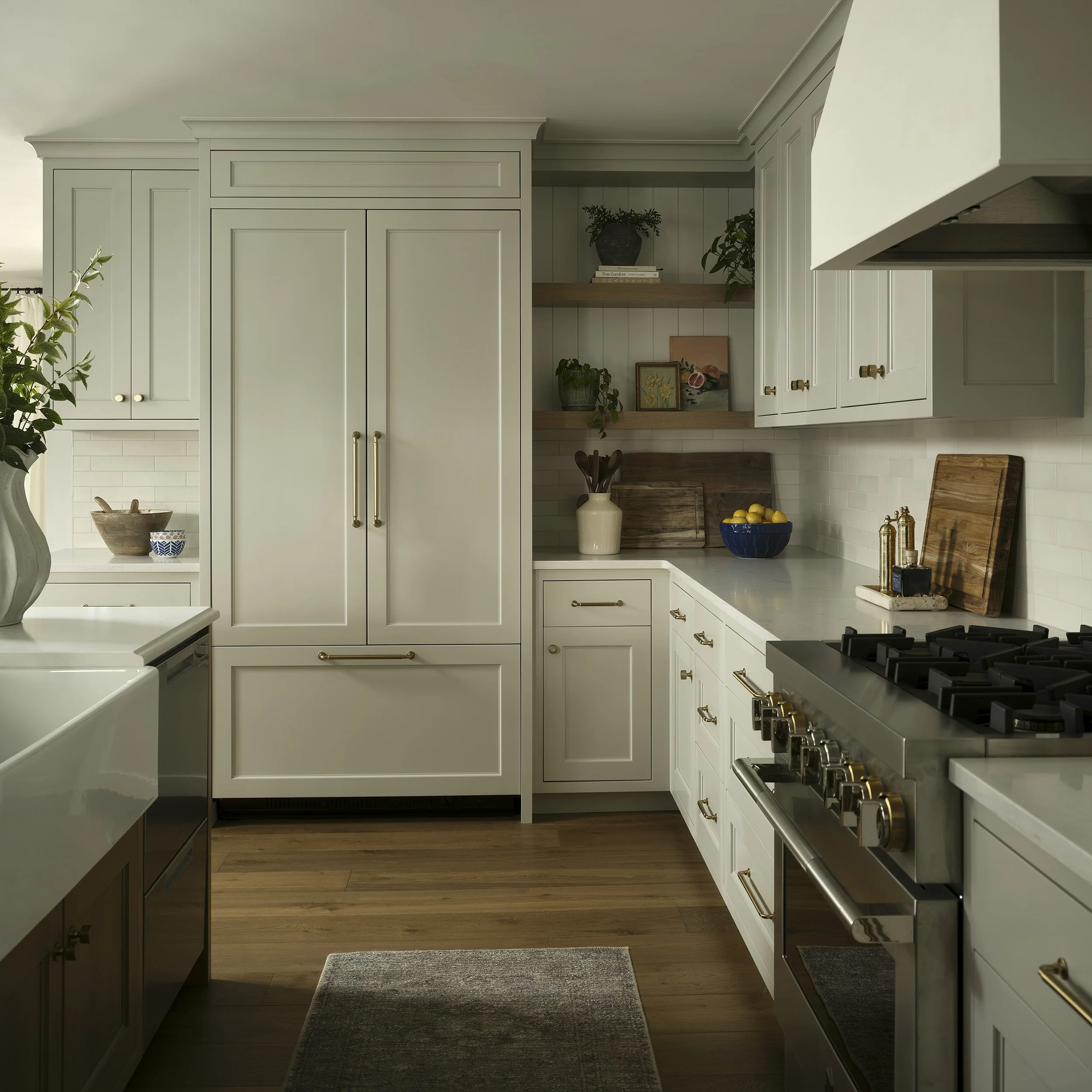 Warm white kitchen remodel with custom cabinetry and brass range details in Denver home