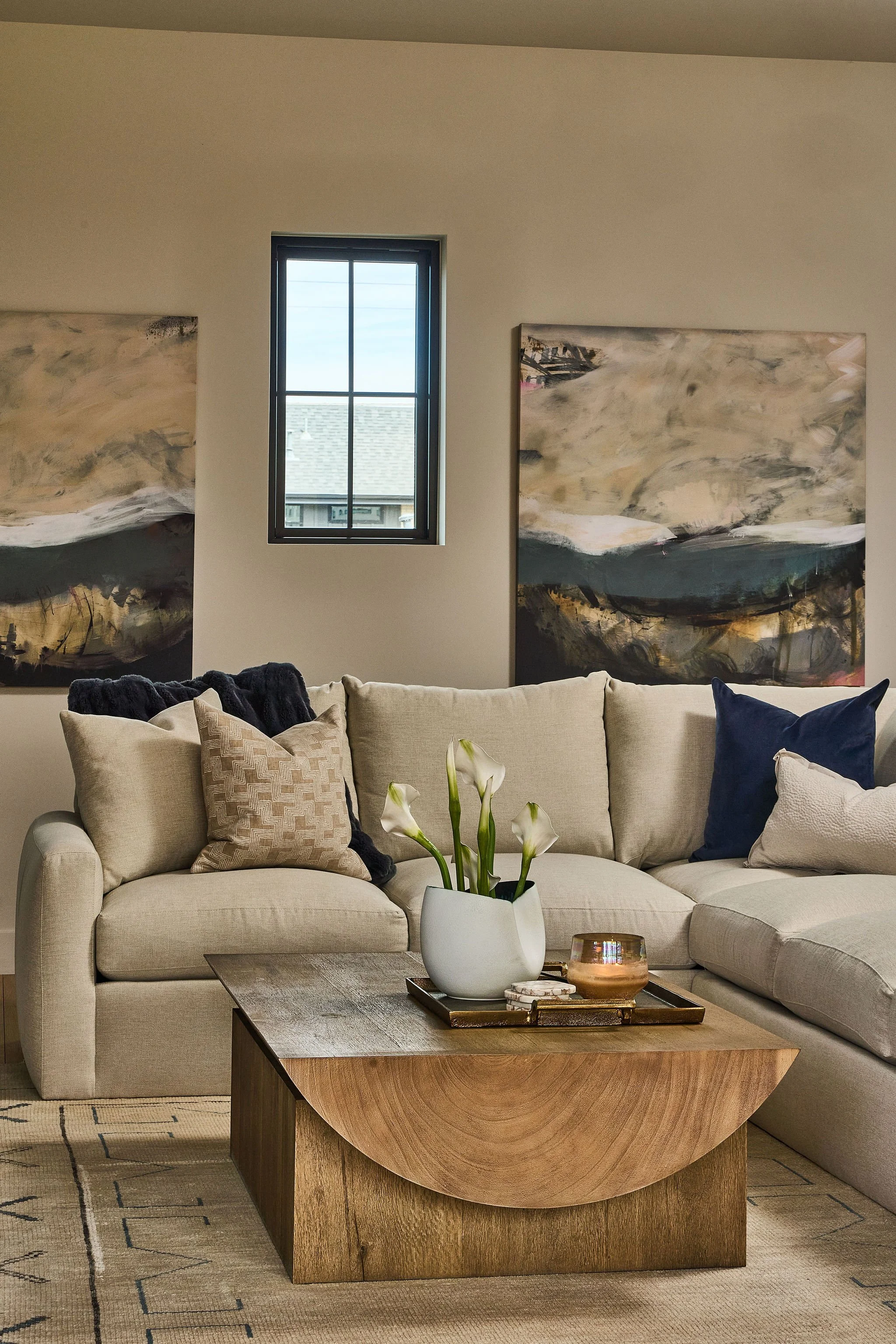 Neutral Denver living room with curved wood coffee table and layered sectional seating