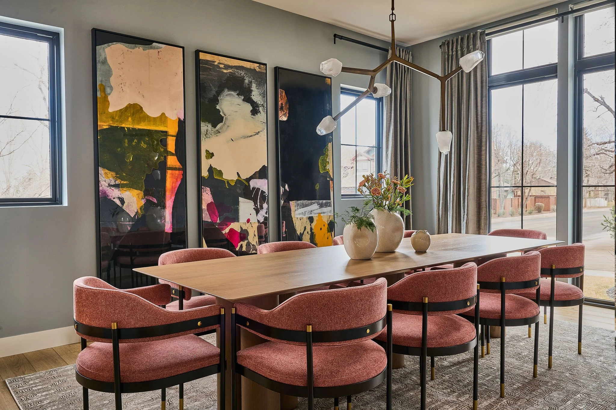 Moody Denver dining room with layered artwork and upholstered blush chairs