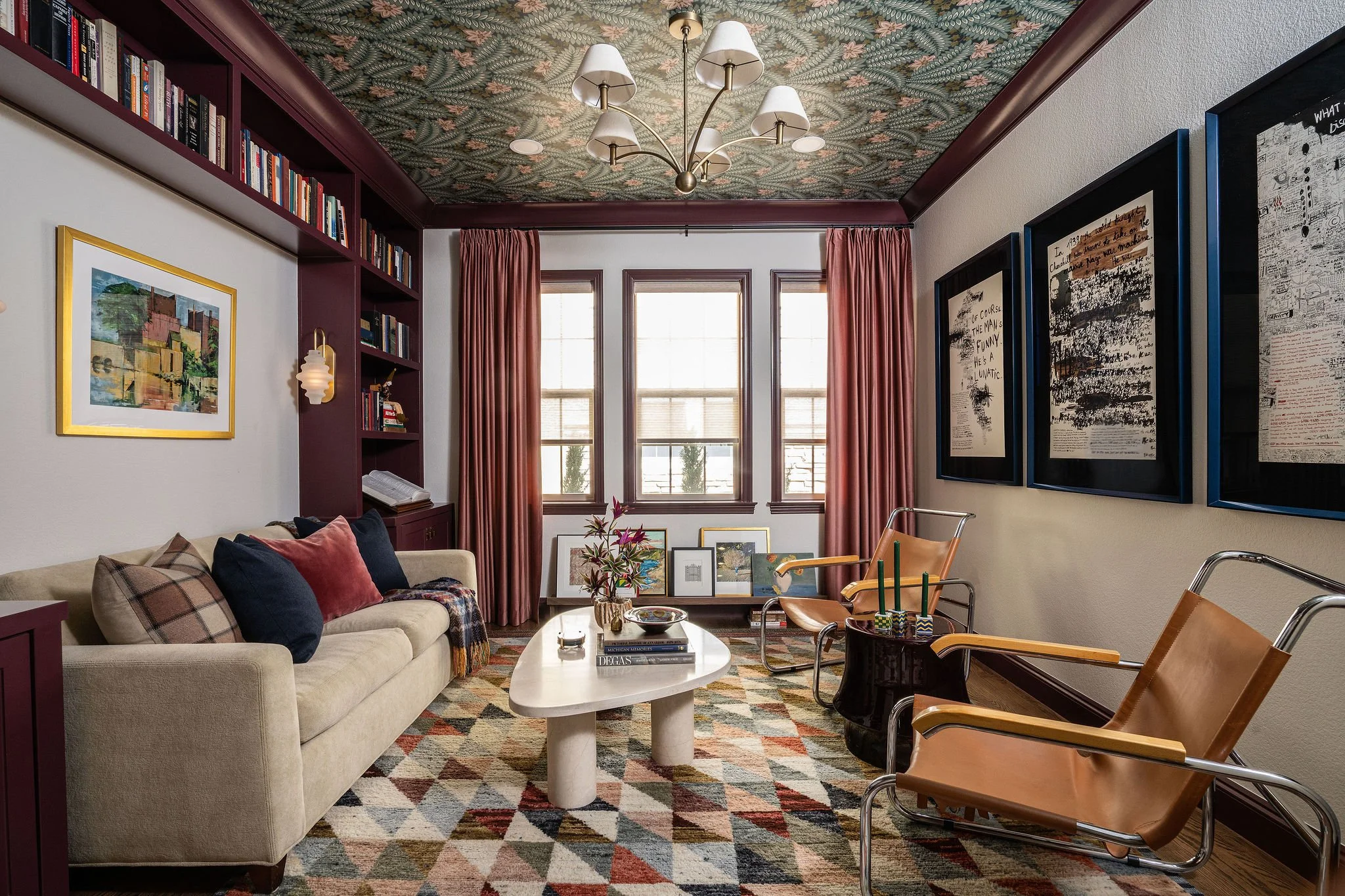 layered den with artwork dark millwork and velvet drapes