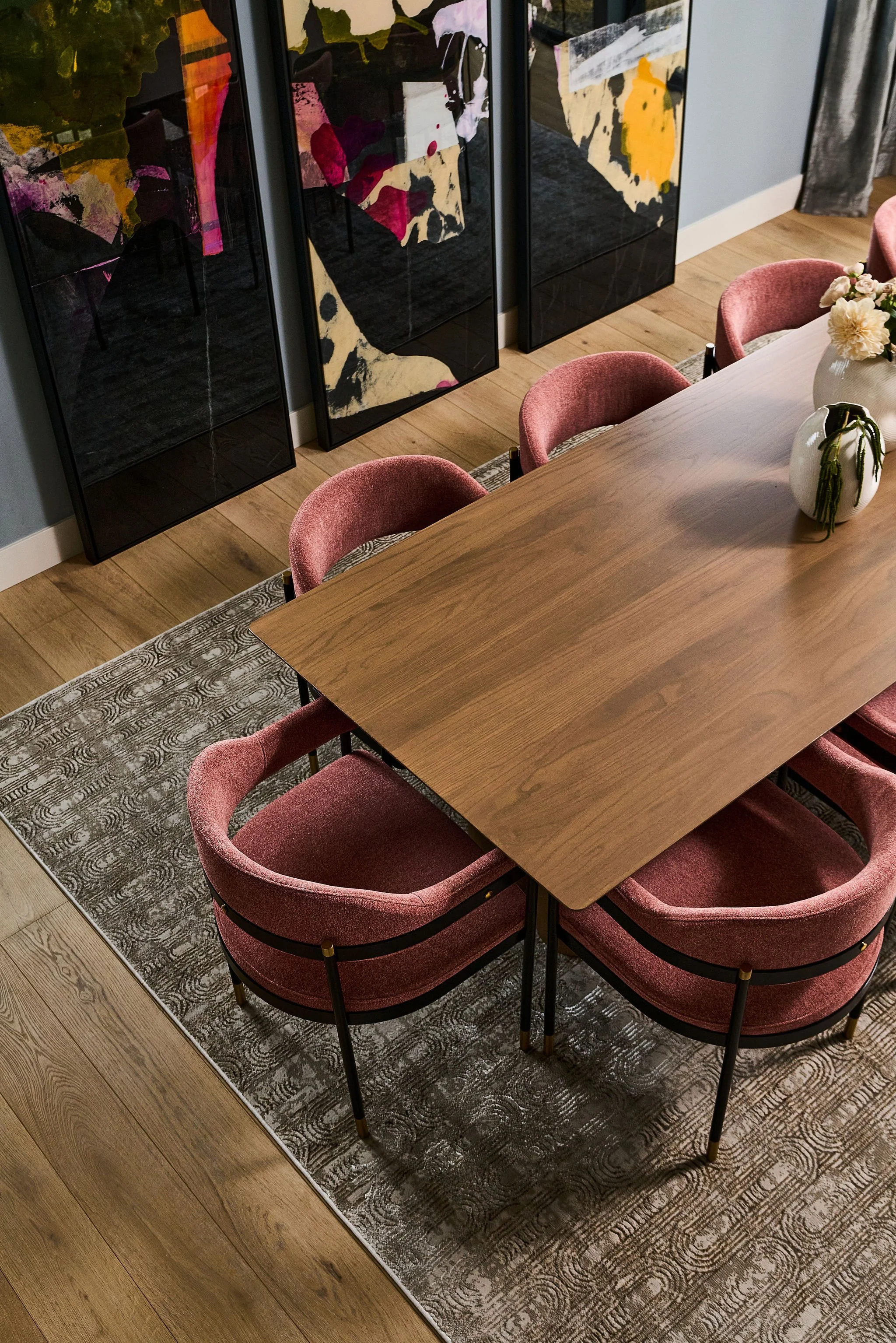 dining room table with pink chairs & colorful art