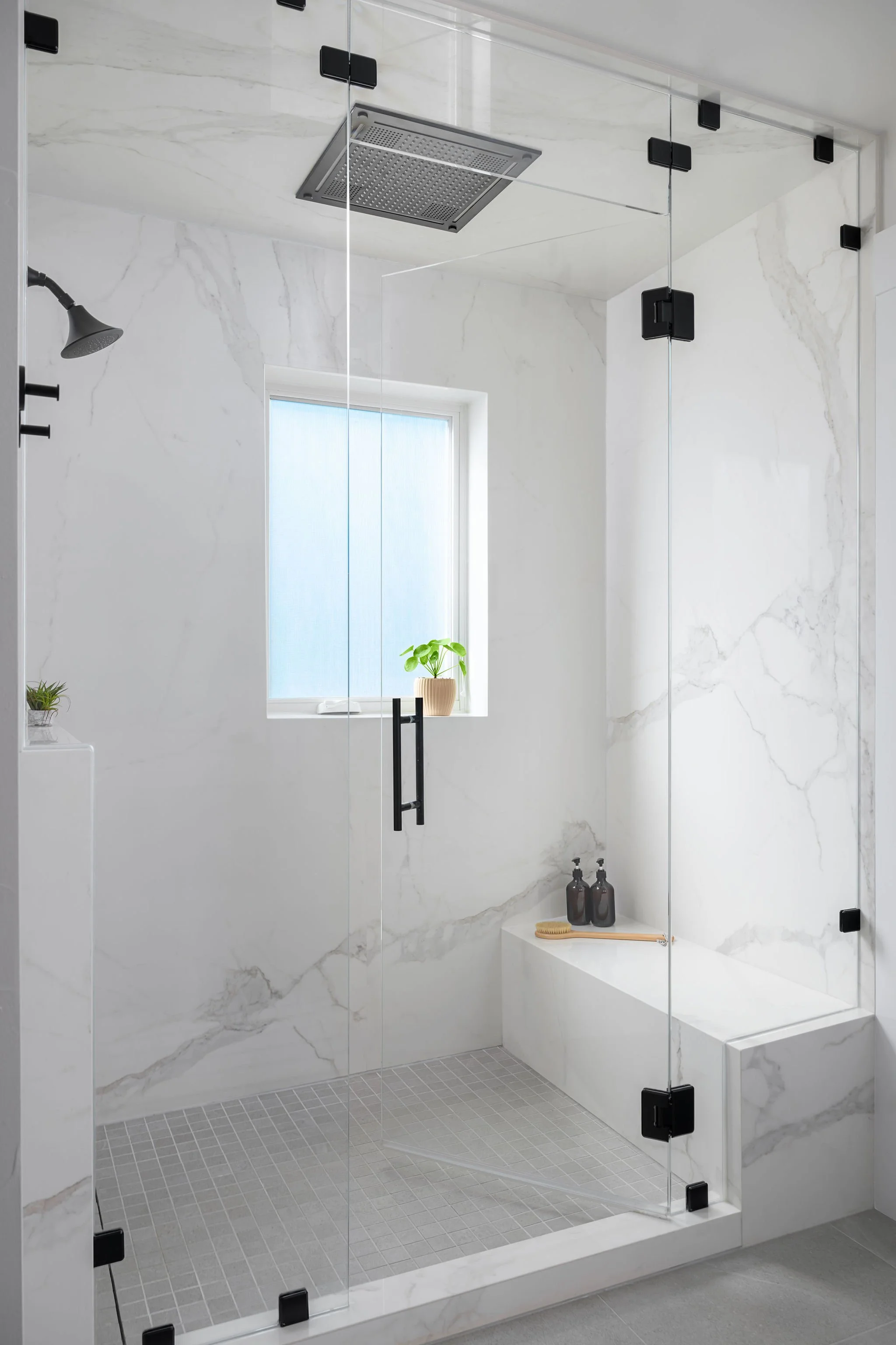 Walk-in steam shower with slab shower walls and rain showerhead in Lafayette bathroom remodel
