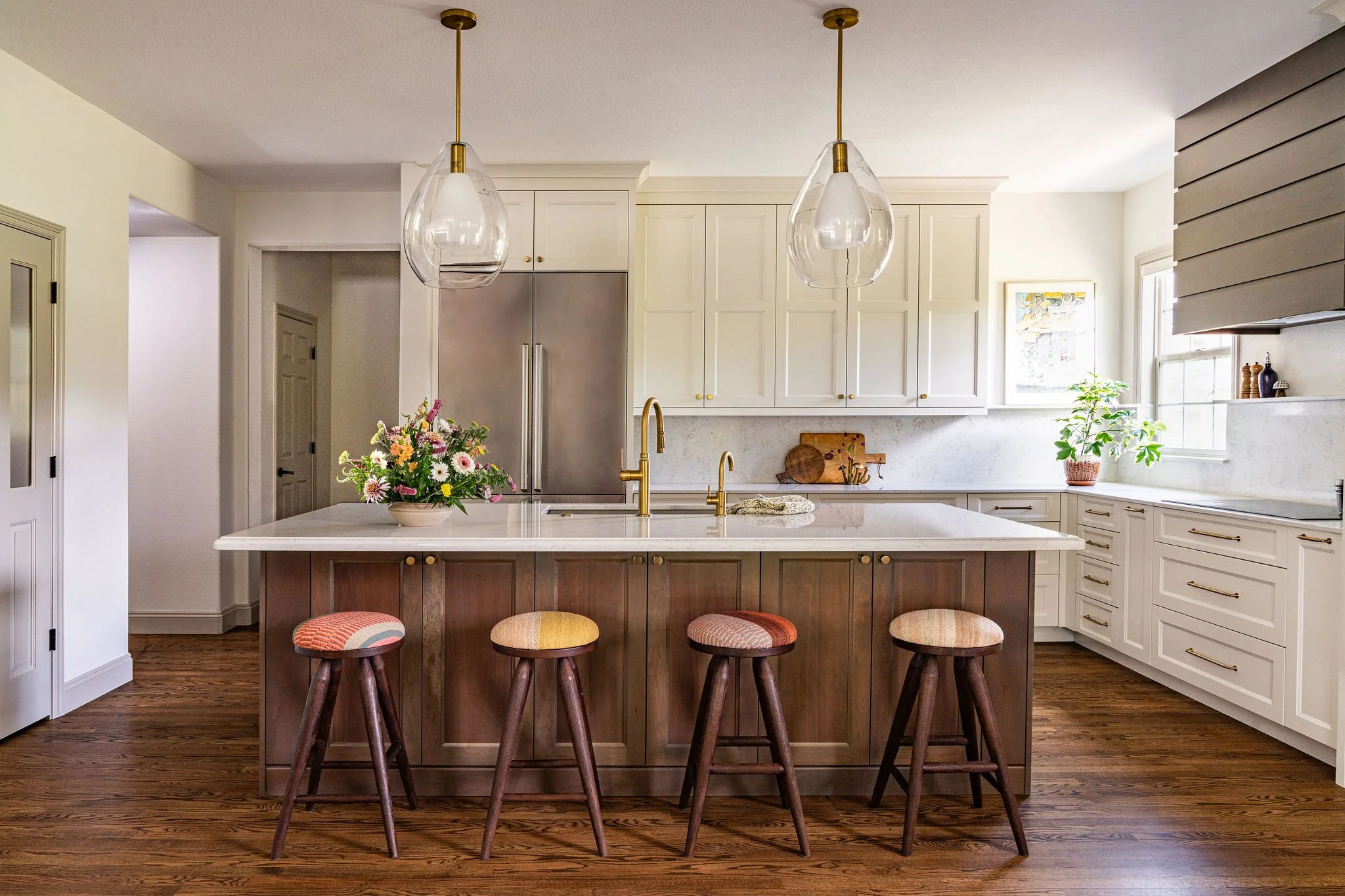 white kitchen with wood island and colorful counter stools