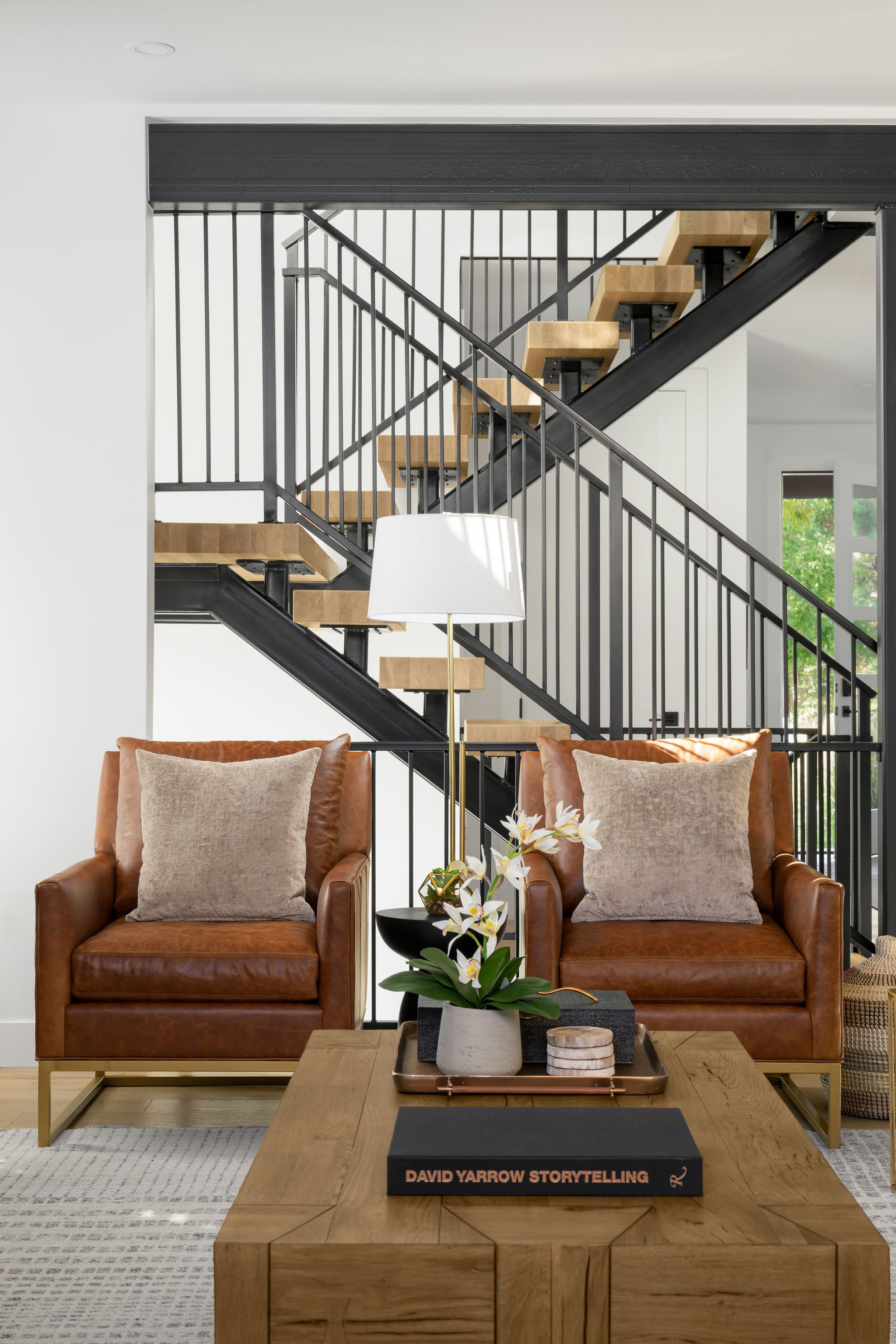 modern floating stairs with leather chairs and wood coffee table