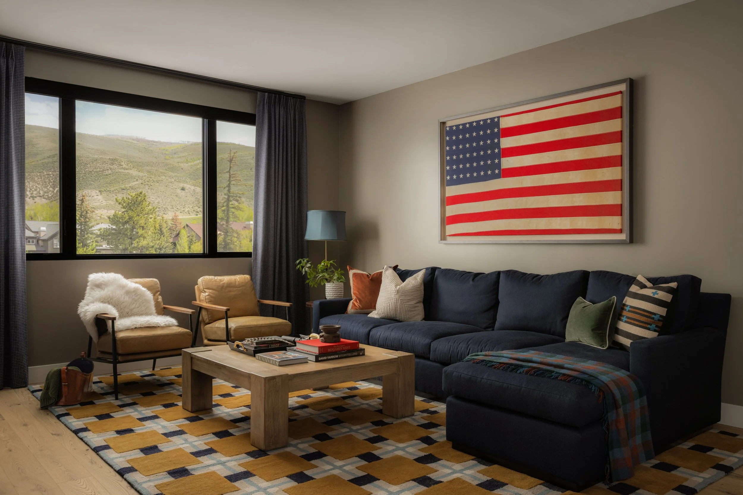 Avon mountain condo living room with layered furnishings, oversized American flag artwork, and cozy masculine details