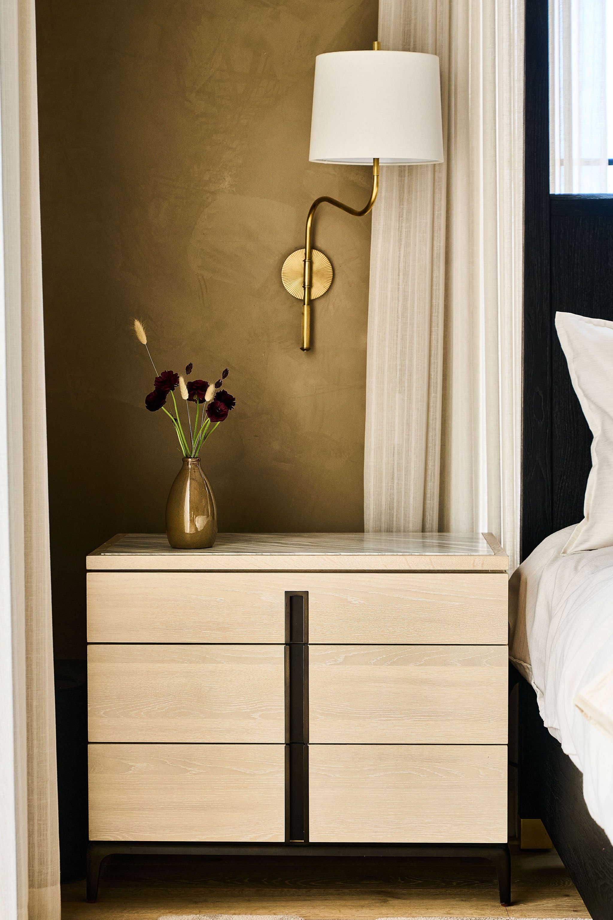 wood & bronze nightstand with brass wall sconce roman clay walls